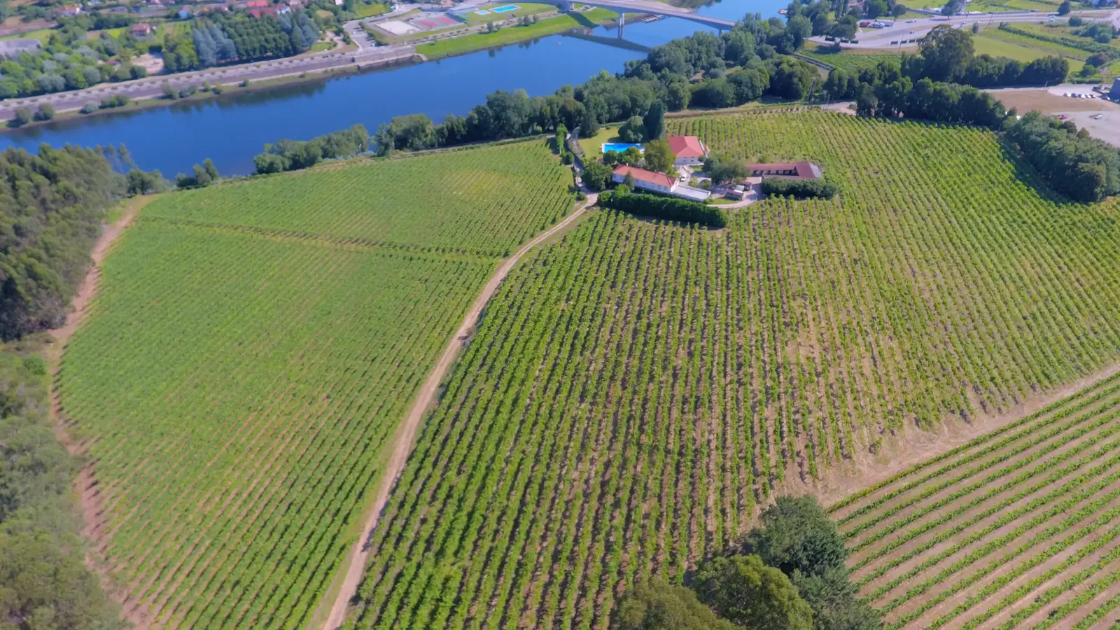 Vista aérea da quinta entre vinhas, com o rio Minho e a ponte internacional ao fundo